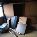 畳の部屋に固めておいてある不用品の木材の写真